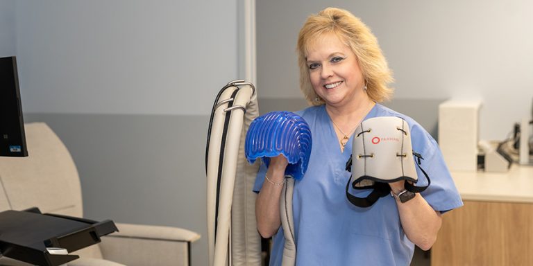 Profesional aplicando tratamiento de frío localizado sobre el cuero cabelludo de un paciente