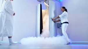 Persona en cabina de crioterapia de cuerpo entero durante sesión profesional