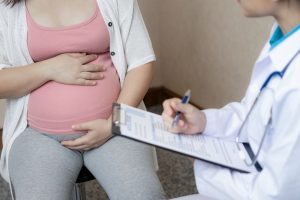 Mujer embarazada consultando con médico sobre tratamientos durante gestación