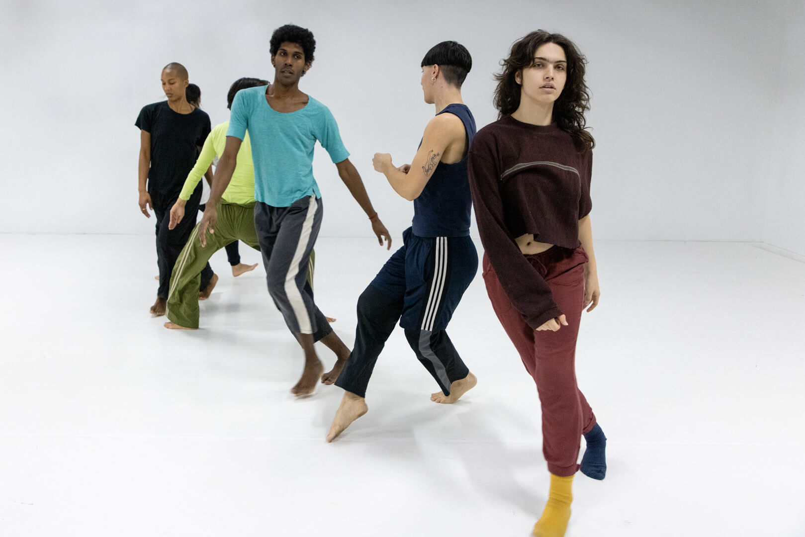 Bailarín contemporáneo con cabello empapado en sudor descansando entre ensayos