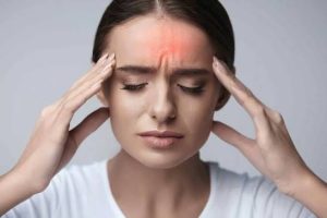 Persona con crisis de migraña sujetándose la cabeza con dolor intenso