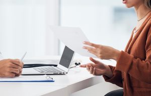 Paciente tomando notas durante una consulta de valoración capilar con un profesional