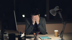 Directivo agotado en su despacho al final de una jornada larga