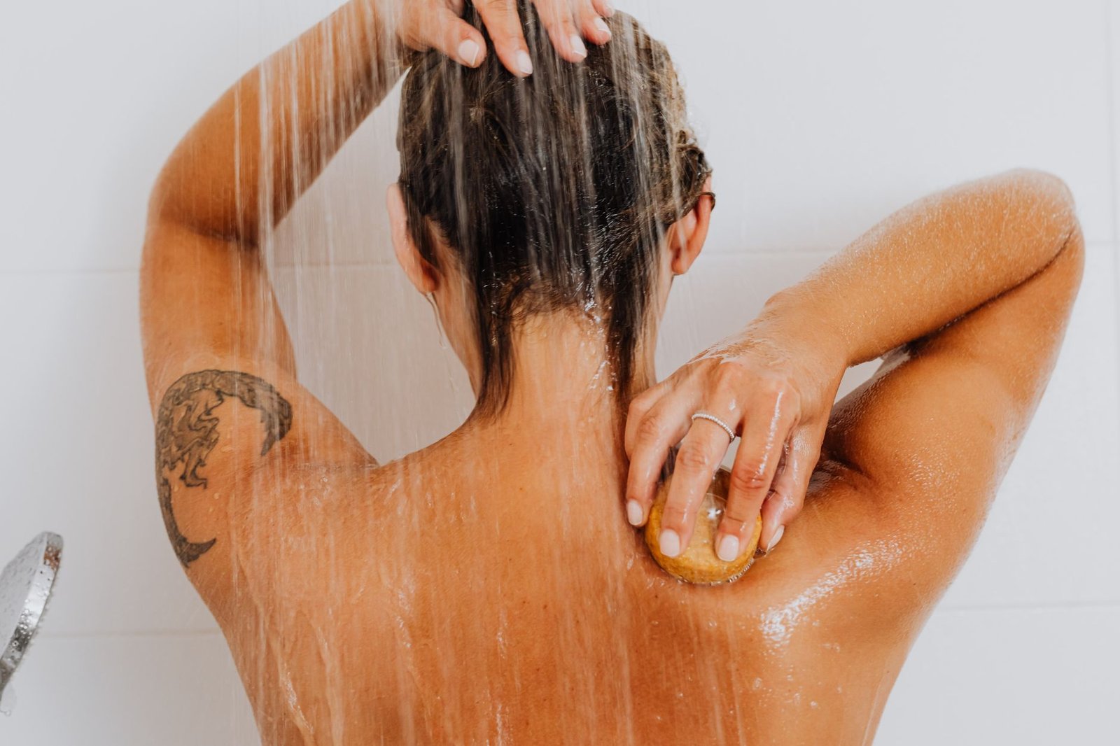 Persona aclarando el cabello con agua dulce abundante antes de nadar