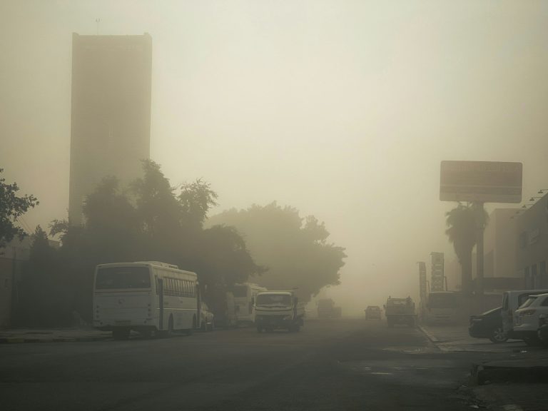 Cielo urbano velado por bruma ocre durante un episodio de polvo sahariano